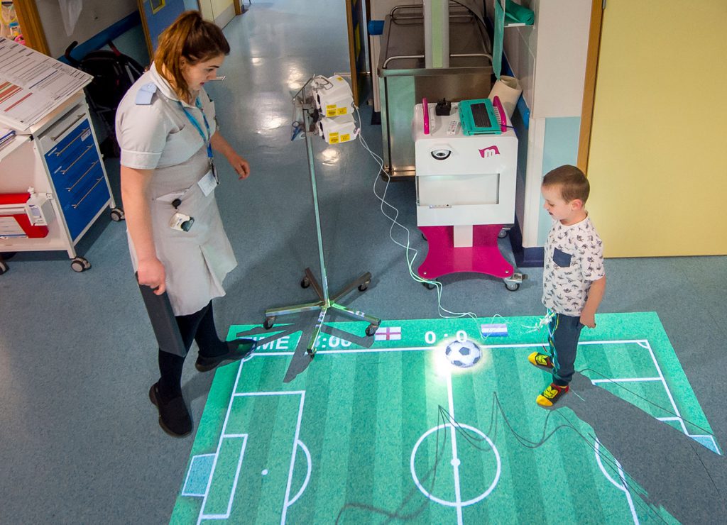 The Cardiac Ward in Bristol's Children’s Hospital. The little boy is playing on a ‘Magic Carpet’, an interactive projector with sensors which enables the kids to play games on the floor.